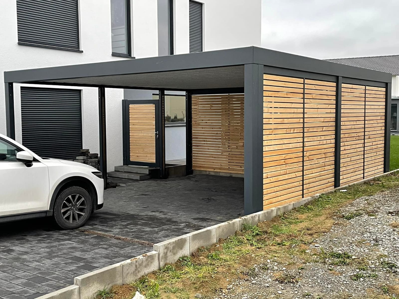 Carport mit Aluminiumwänden in Holzoptik am modernen Haus